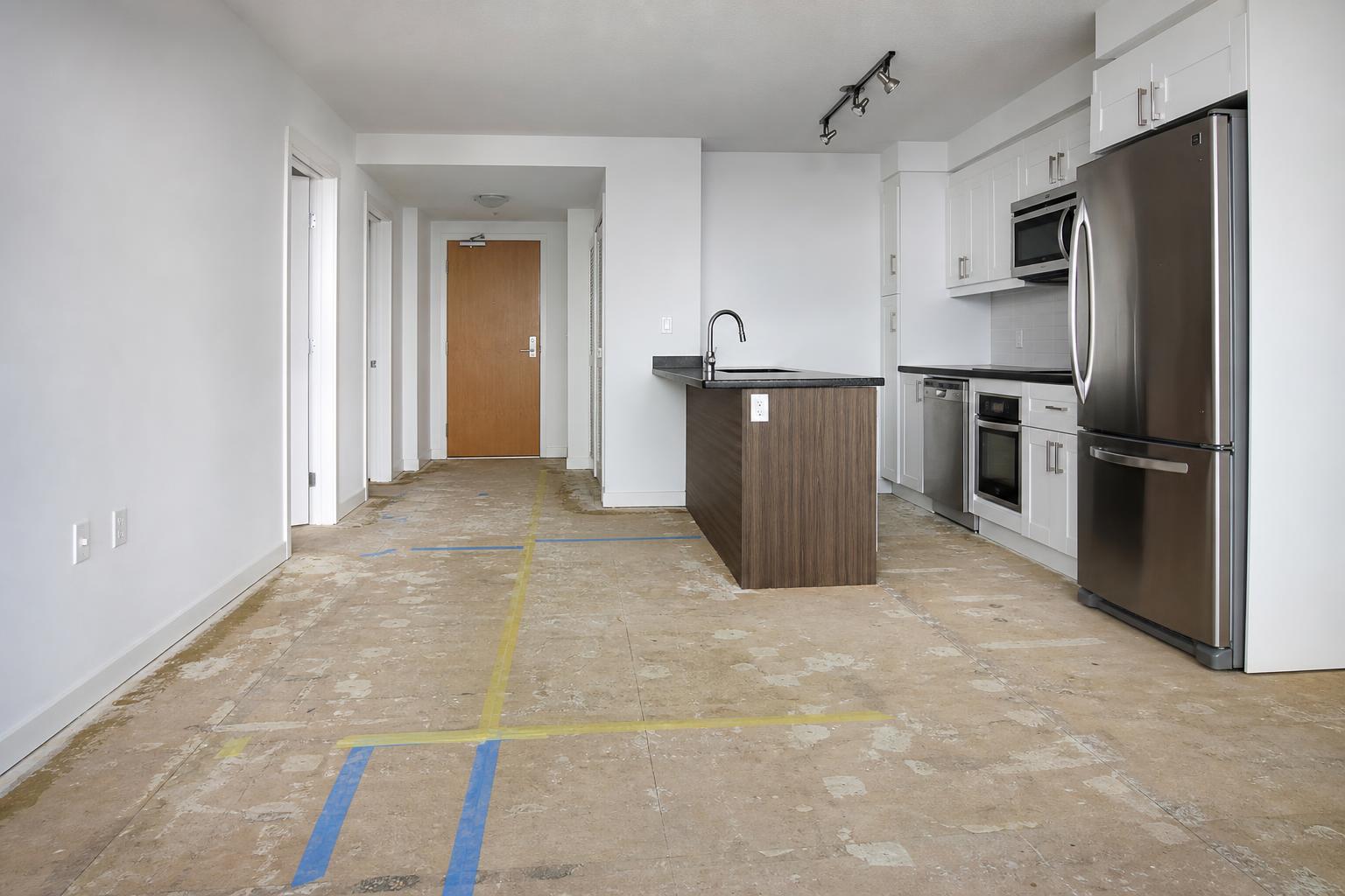 Worn dated floor with scuffed laminate and tired carpet before renovation